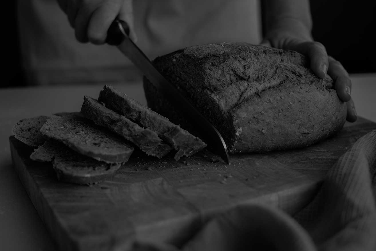 mano-panadero-rebanando-pan-fresco-cuchillo